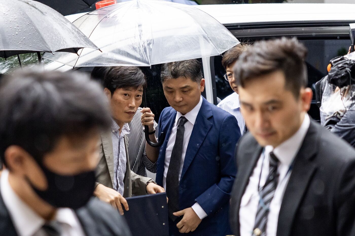 Brian Kim, centre right, arrives at the Seoul Southern District Court in Seoul on July 22. Photographer: SeongJoon Cho/Bloomberg