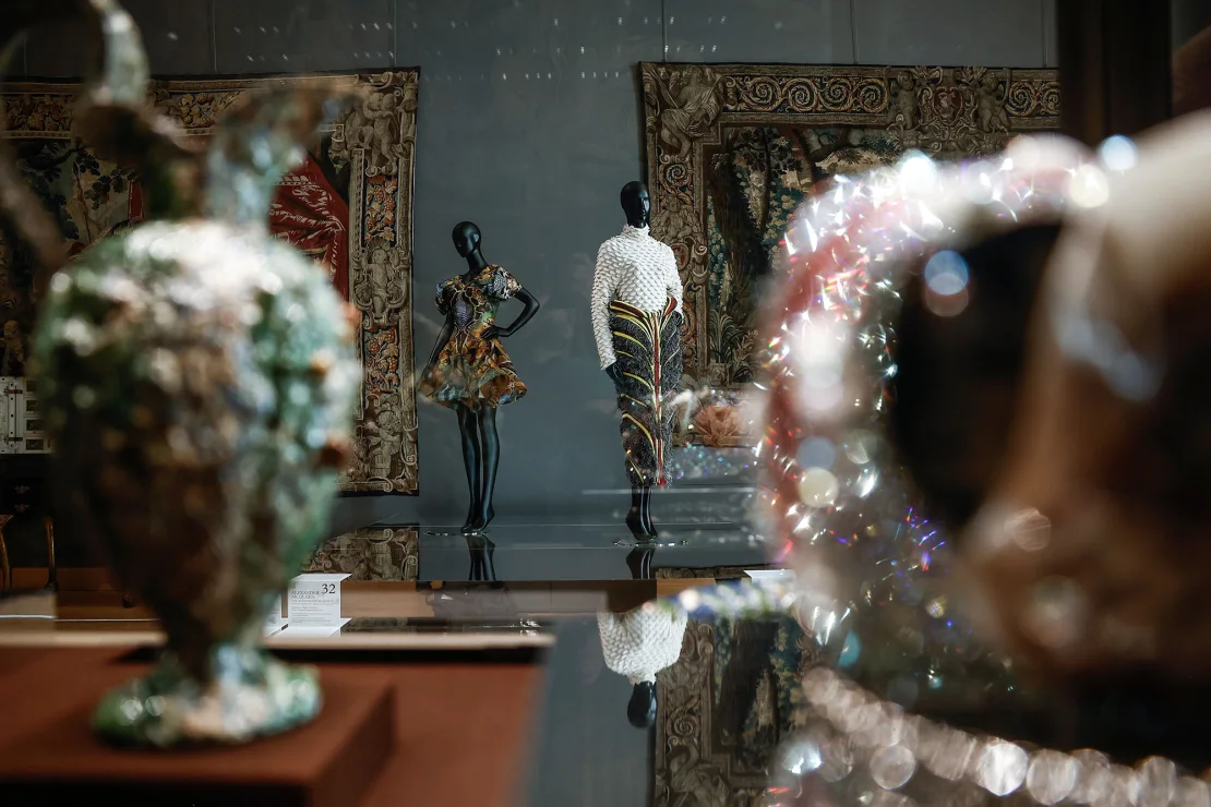 Fashion creations, including a dress from Alexander McQueen's Spring-Summer 2010 collection (left) on show at the Louvre museum. Image source: Yoan Valat/EPA-EFE/Shutterstock via CNN